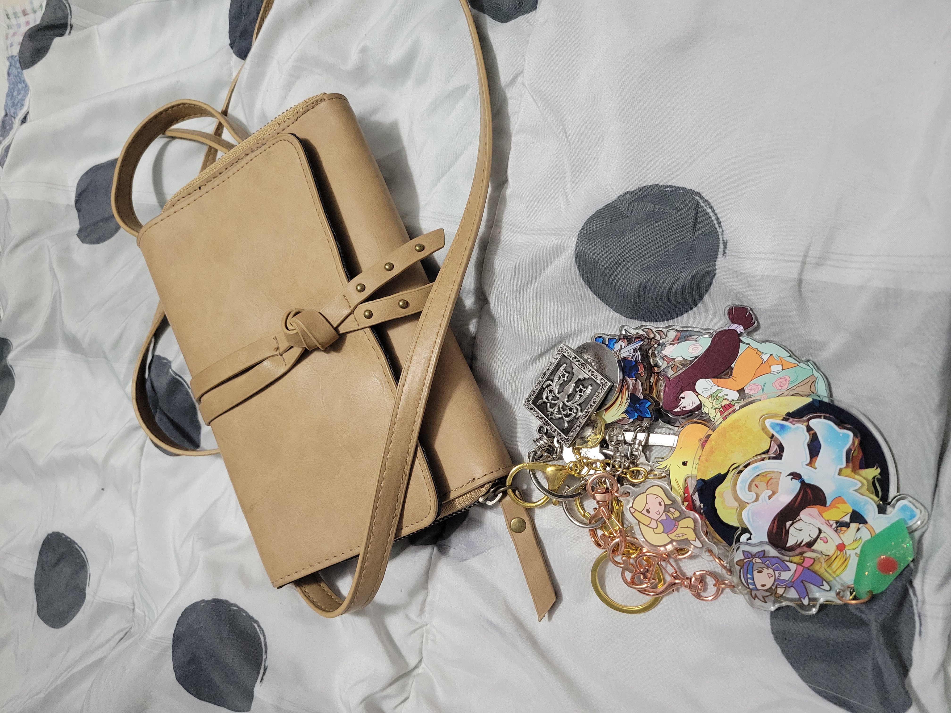 Brown crossbody bag decorated with a large collection of acrylic Final Fantasy keychains.